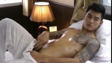 Thai guy comforting his cock on bed solo masturbation